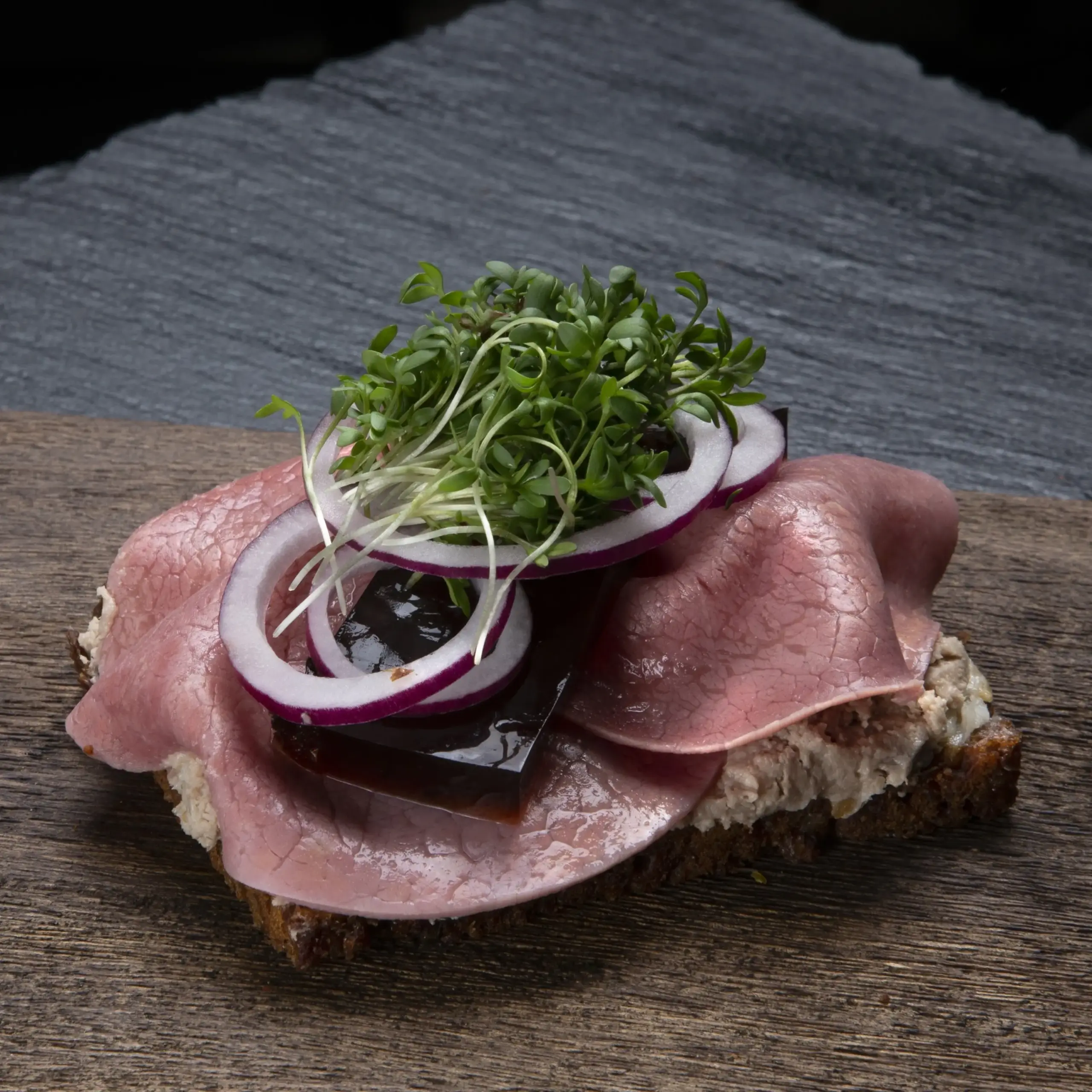 Smørrebrød Dyrlægens Natmad på rugbrød fra Ibens Smørrebrød i København med leverpostej, saltet kød, sky, rødløg og karse