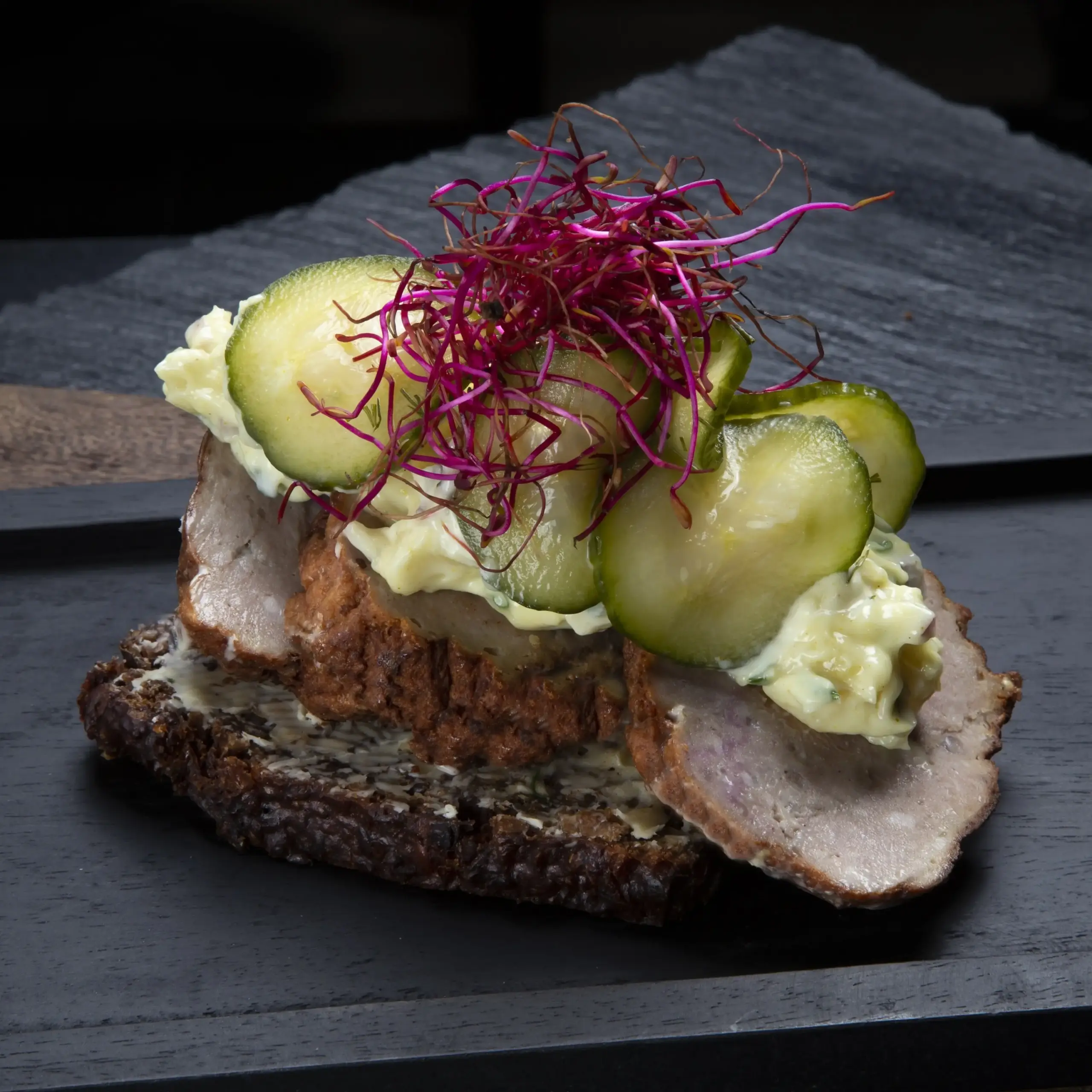 Smørrebrød med frikadelle på rugbrød fra Ibens Smørrebrød i København med hjemmelavet remoulade, sprøde syltede agurker og spirer