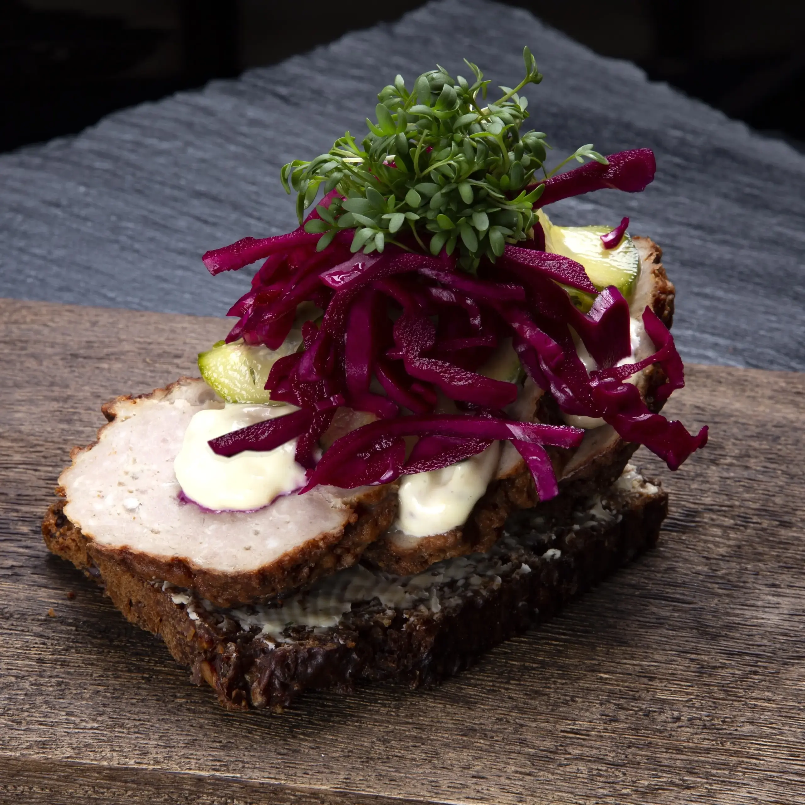 Smørrebrød med frikadelle på rugbrød fra Ibens Smørrebrød i København med hjemmerørt mayonnaise, sprød råsyltet rødkål og karse