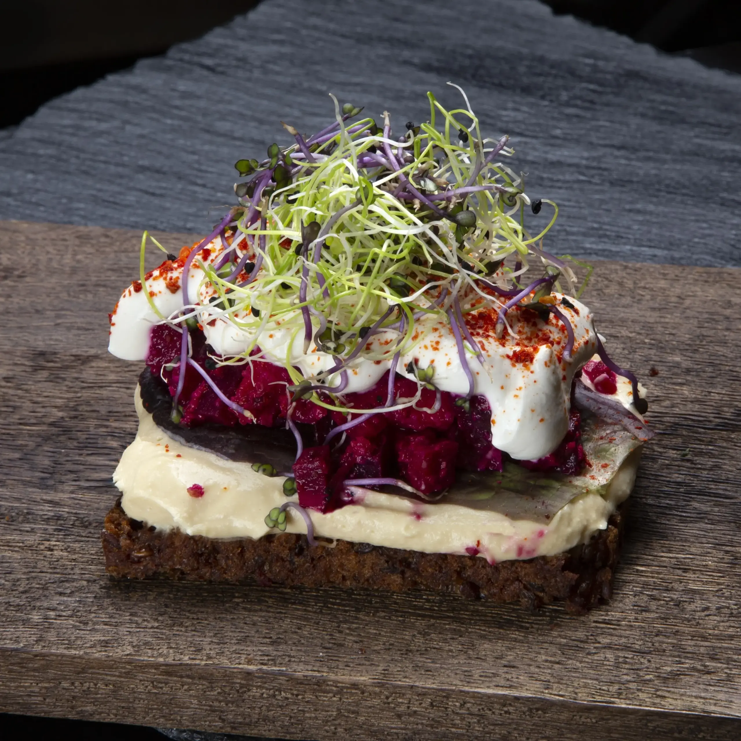 Vegetarisk smørrebrød med hjemmelavet hummus og rødbedetatar på rugbrød fra Ibens Smørrebrød i København med rygeostcreme, piment d’Espelette og spirer