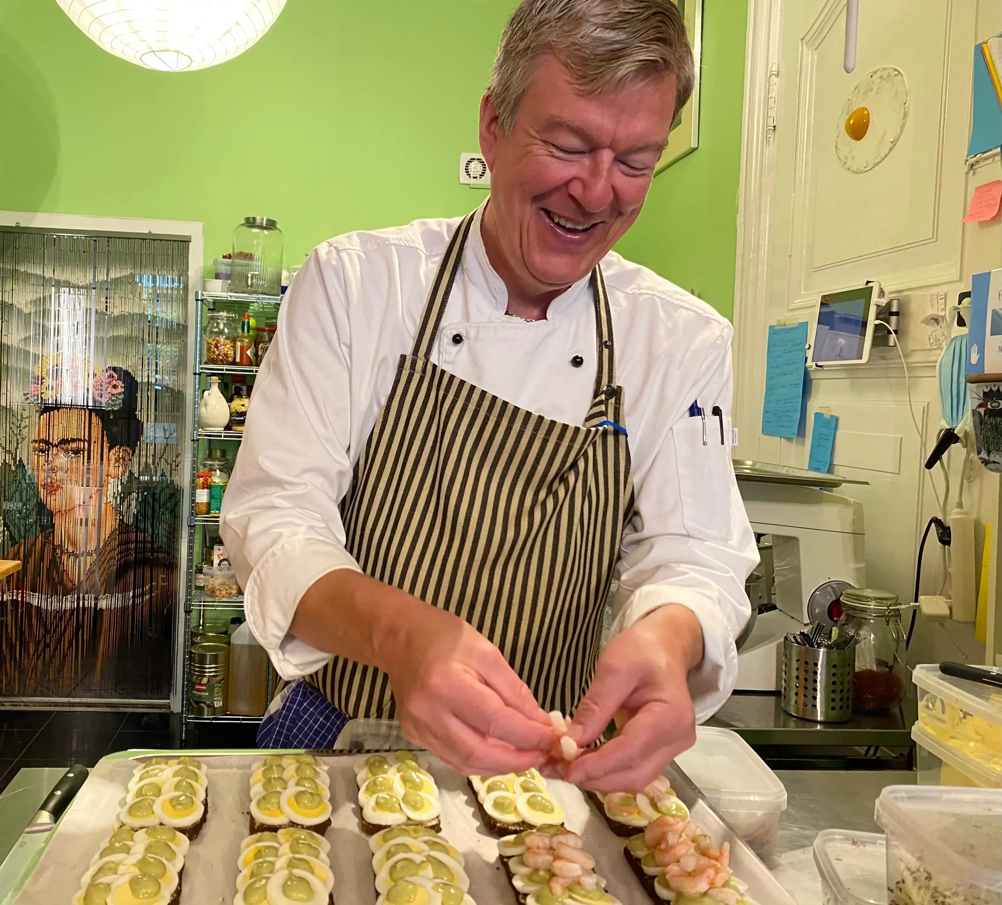Kok og smørrebrødsjomfru Kim Kops gør klar til en travl dag i Danmarks mindste smørrebrødsrestaurant. Her smører han Ibens Smørrebrøds mest populære stykke Æg & Rejer.