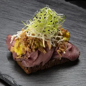 Smørrebrød med roastbeef på rugbrød fra Ibens Smørrebrød i København med hjemmelavet remoulade, ristede løg, peberrod og friske spirer