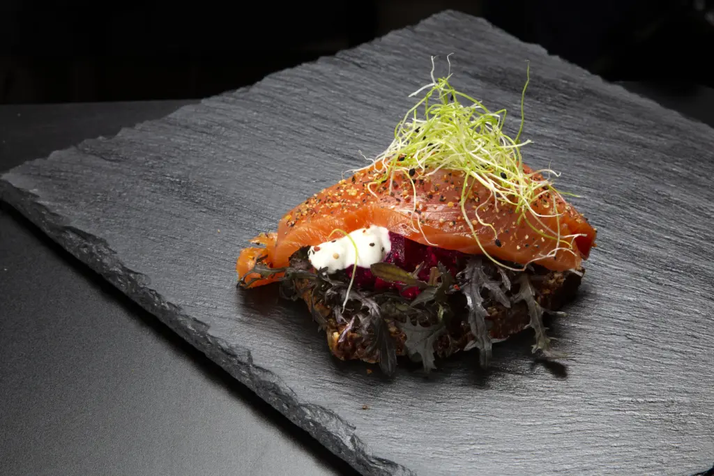 Smørrebrød med røget laks på rugbrød fra Ibens Smørrebrød i København med mizunasalat, rødbedetatar, rygeostcreme, grov peber og spirer